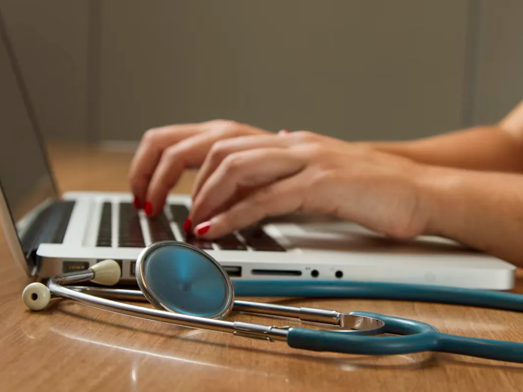 Médecin rédigeant un rapport d'expertise médicale sur ordinateur portable